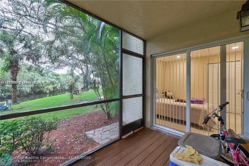 3100 Riverside Drive, Unit 107 Coral Springs, FL 33065 - Photo 29 of 33 a view of a porch with wooden floor and fence