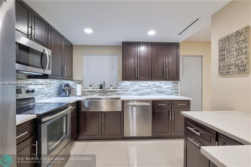 3100 Riverside Drive, Unit 107 Coral Springs, FL 33065 - Photo 3 of 33 a kitchen with stainless steel appliances granite countertop a sink stove and oven