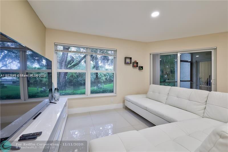 3100 Riverside Drive, Unit 107 Coral Springs, FL 33065 - Photo 33 of 33 a living room with furniture and a large window