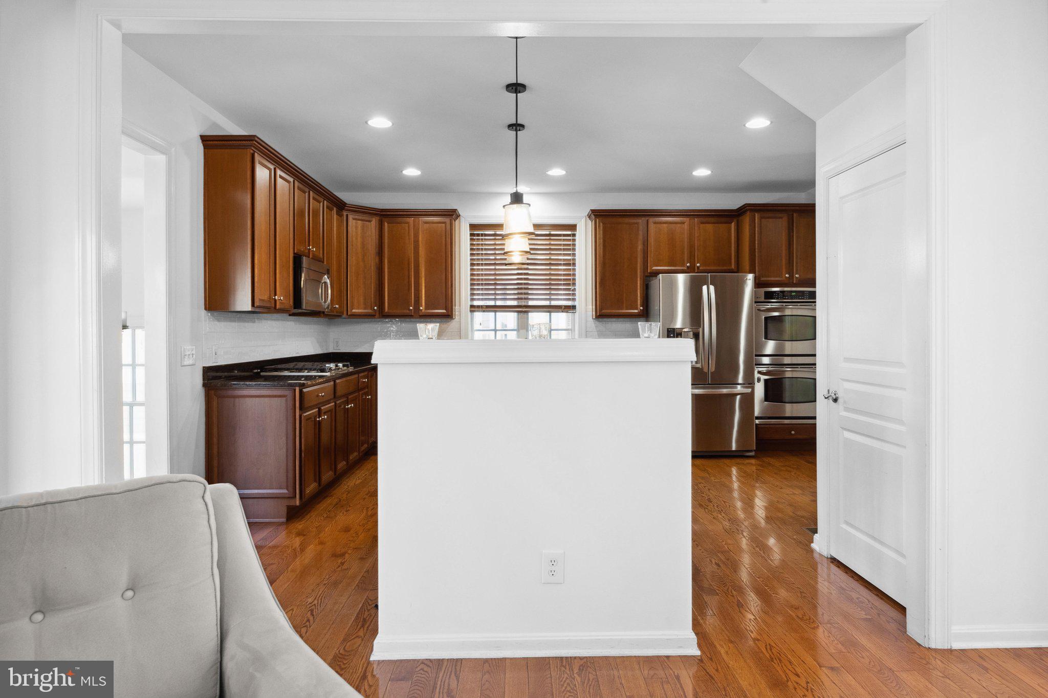 1615 Silver Birch Road Huntingdon Valley, PA 19006 - Photo 15 of 69 a kitchen with stainless steel appliances granite countertop a refrigerator a oven a sink and a dining table with wooden floor