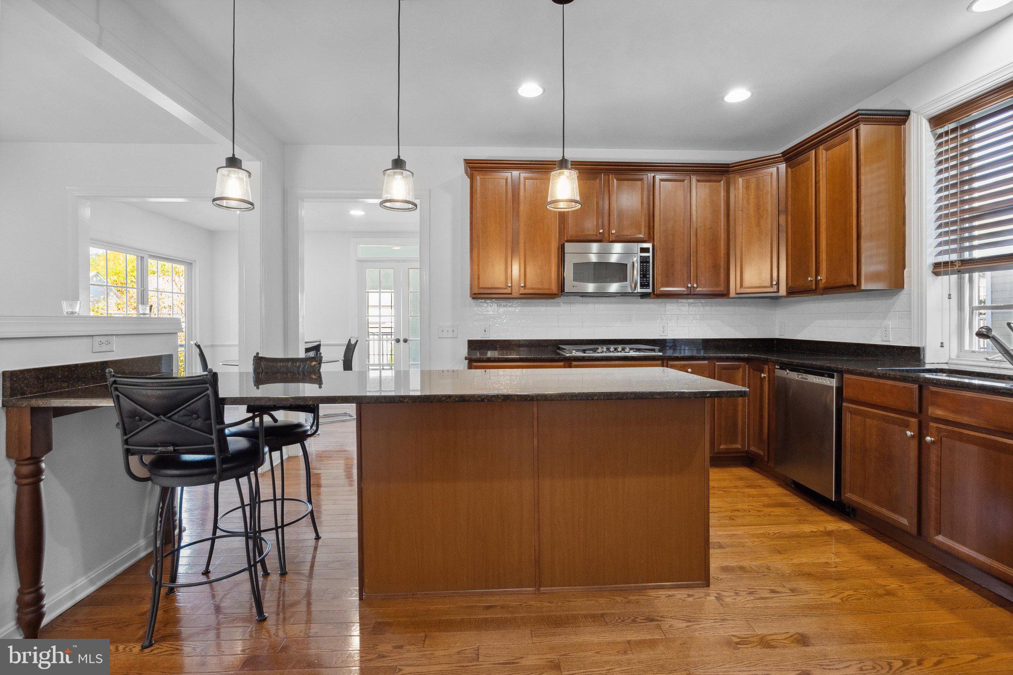 1615 Silver Birch Road Huntingdon Valley, PA 19006 - Photo 16 of 69 a kitchen with stainless steel appliances granite countertop wooden floors a stove a sink and a microwave