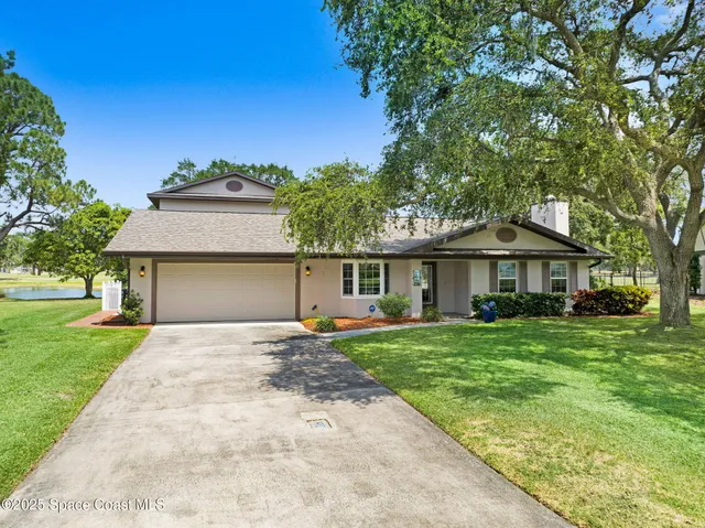 a front view of a house with a yard and trees