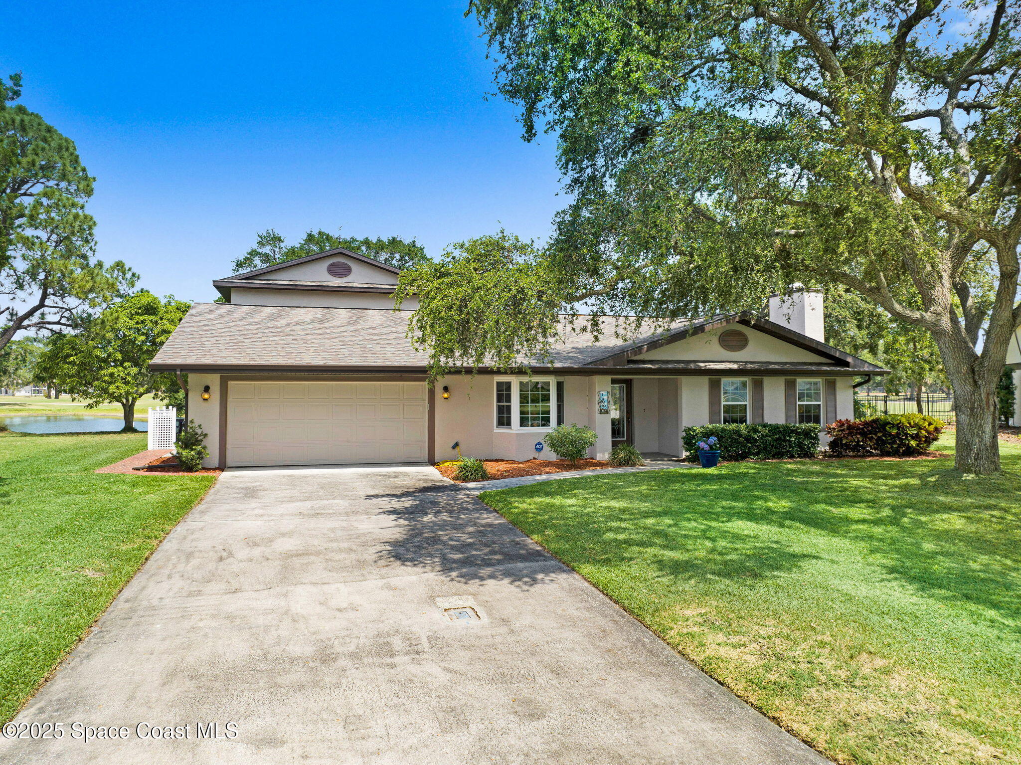 a front view of a house with a yard and trees