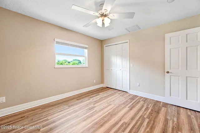 a spacious bedroom with a bed and wooden floor