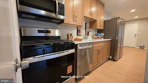 a kitchen with stainless steel appliances a stove a sink and cabinets