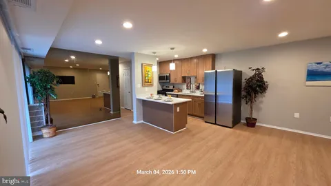 a kitchen with stainless steel appliances kitchen island granite countertop a refrigerator and a sink