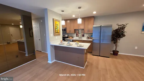 a kitchen with stainless steel appliances kitchen island granite countertop a sink refrigerator and cabinets