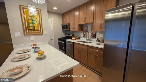 a kitchen with stainless steel appliances granite countertop a sink a stove and a refrigerator