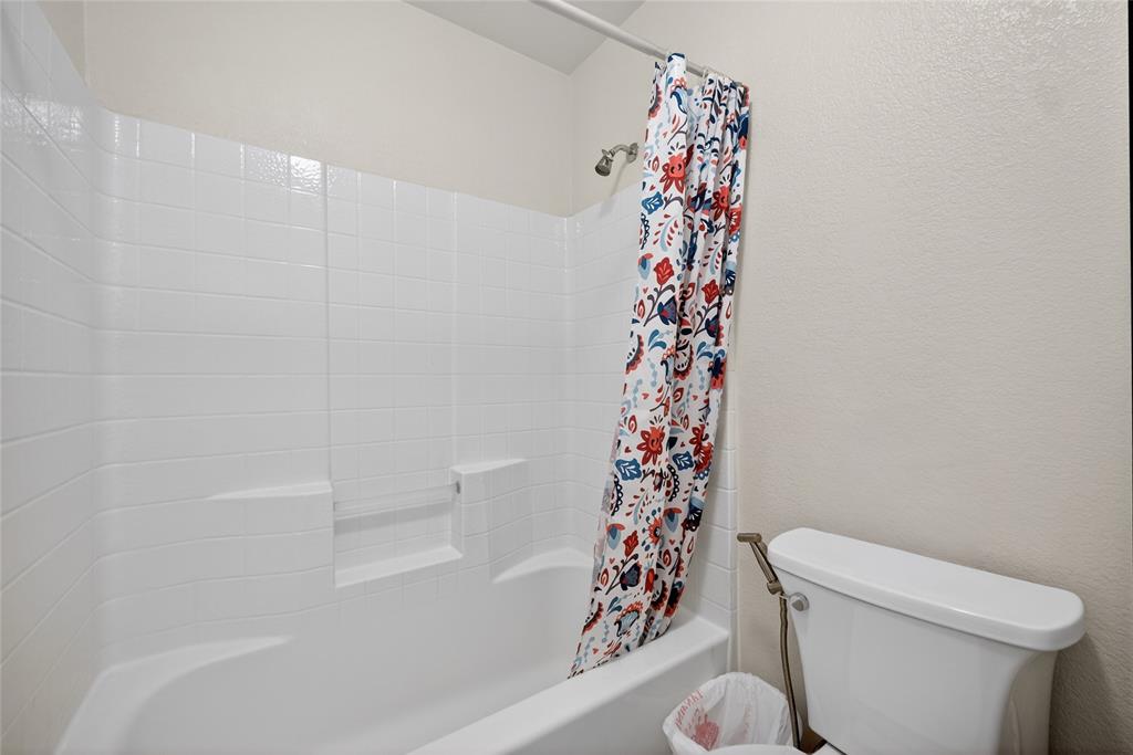 9633 Anns Way Plano, TX 75025 - Photo 30 of 37 a white toilet sitting next to a shower curtain