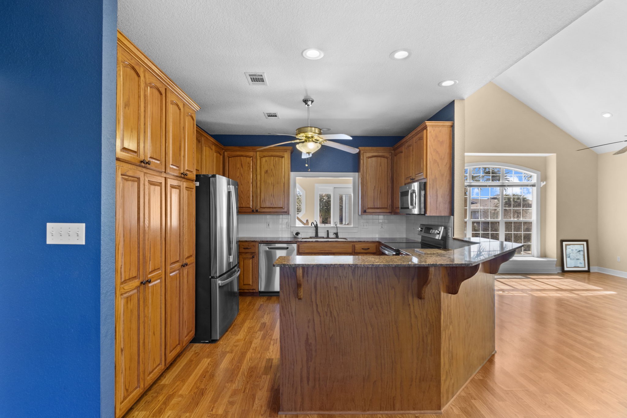 900 Southwind Port Arthur, TX 77640 - Photo 30 of 38 a kitchen with stainless steel appliances granite countertop a refrigerator a sink dishwasher a stove and a dining table with wooden floor