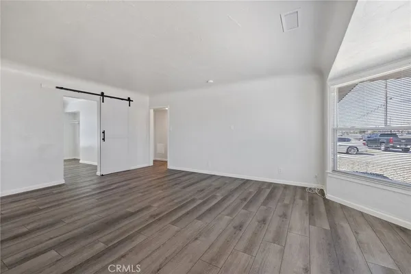 a view of a room with wooden floor and a bathroom