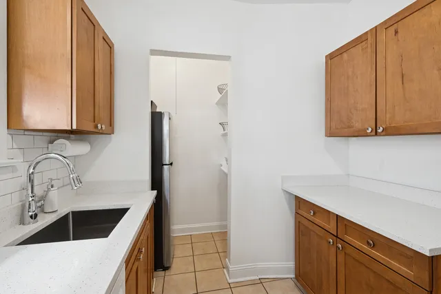 a kitchen with stainless steel appliances granite countertop a sink and a refrigerator with wooden cabinets