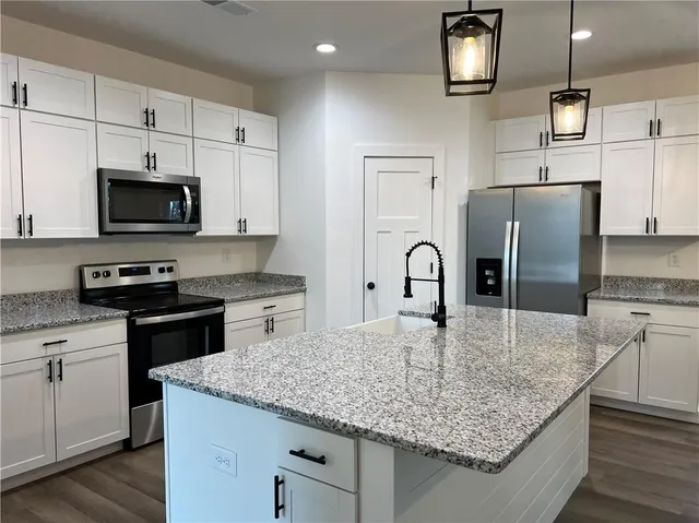 a kitchen with kitchen island a counter space a sink and appliances
