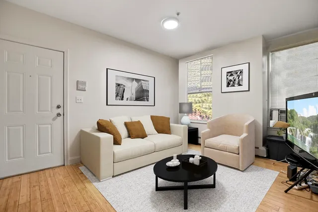 a living room with furniture a rug and a window