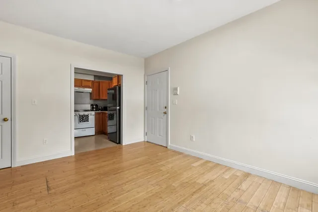a view of a kitchen with wooden floor and a refrigerator