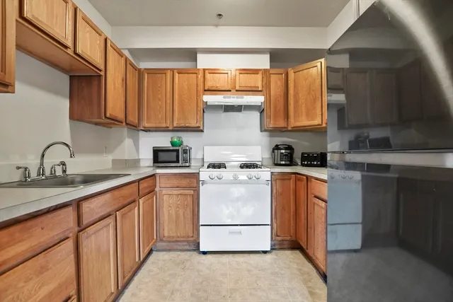 a kitchen with stainless steel appliances granite countertop a stove a sink dishwasher and a refrigerator