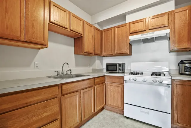 a kitchen with stainless steel appliances granite countertop a sink a stove and a refrigerator