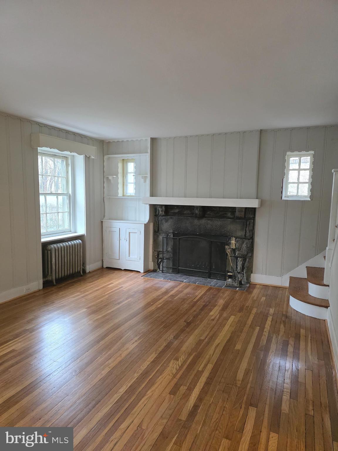 14 Avon Road Narberth, PA 19072 - Photo 3 of 17 an empty room with wooden floor fireplace and windows