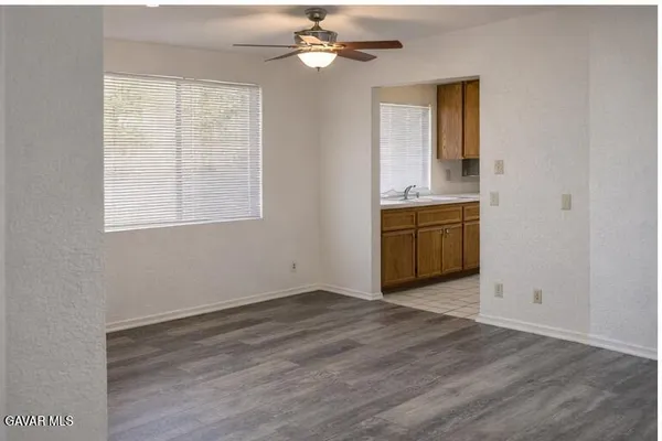 a view of an empty room with window and wooden floor