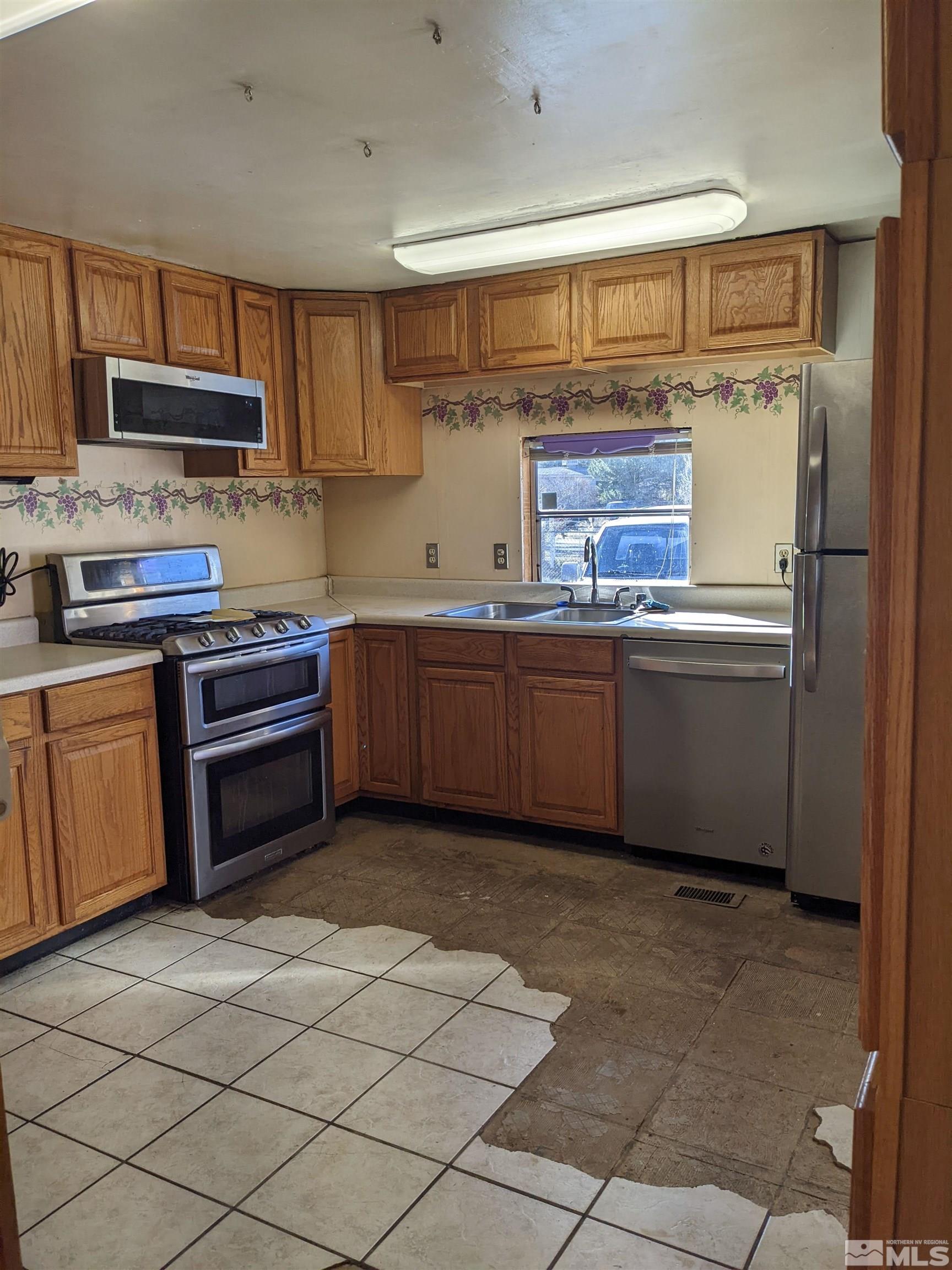 3960 Goldfinch Drive Reno, NV 89508 - Photo 3 of 15 a kitchen with stainless steel appliances granite countertop a stove sink and cabinets
