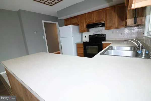 a kitchen with a refrigerator sink and cabinets