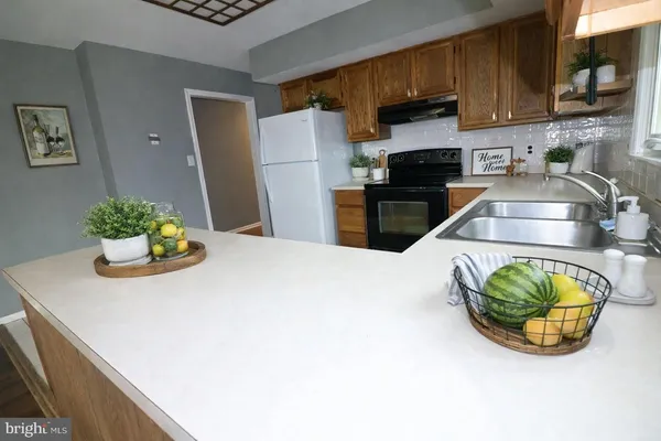 a kitchen with stainless steel appliances a sink a microwave a refrigerator and cabinets