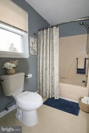 a white toilet sitting next to a bathroom sink and tub