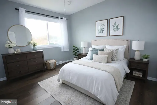 a bedroom with a bed a mirror on desk and a window