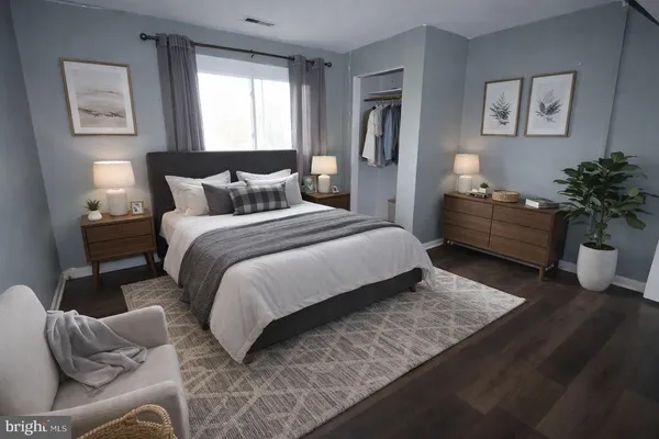 a view of an empty room with wooden floor and closet