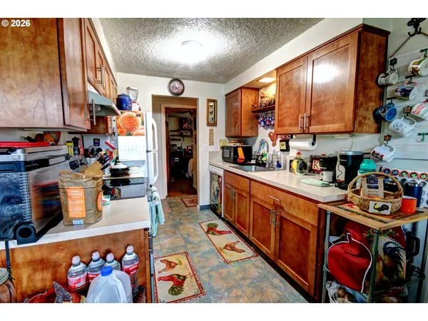 a large kitchen filled with lots of clutter and stainless steel appliances