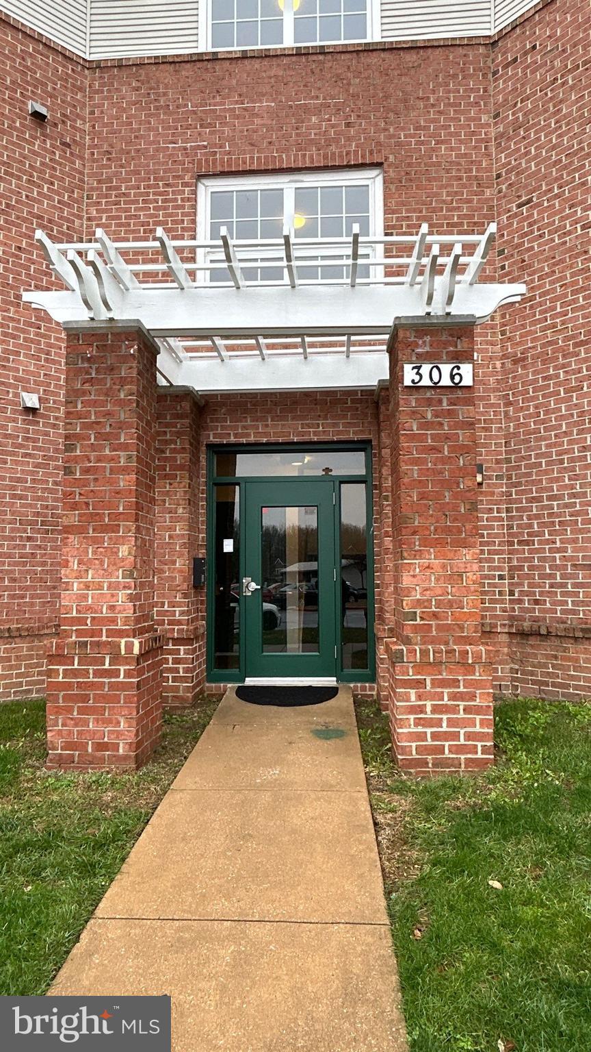 306 Gatehouse Lane, Unit E Odenton, MD 21113 - Photo 2 of 14 a front view of a house with a garden
