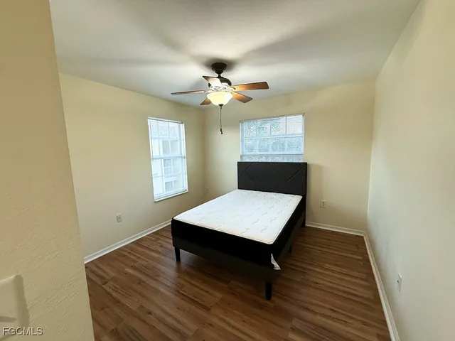 a room with wooden floor pool table and a window