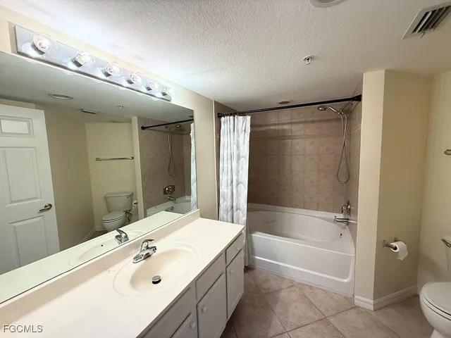 a bathroom with a tub a sink shower and mirror