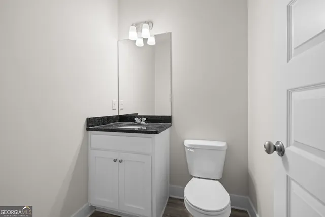a bathroom with a toilet a sink and a mirror