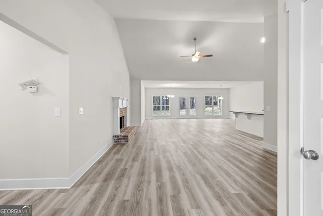 a view of a hallway with wooden floor and a bathroom