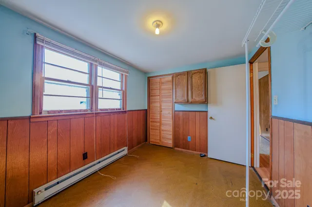 an empty room with windows chandelier fan and windows
