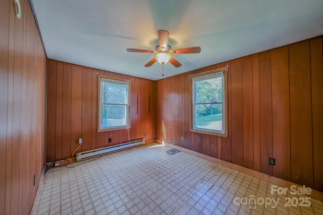 an empty room with windows and fan