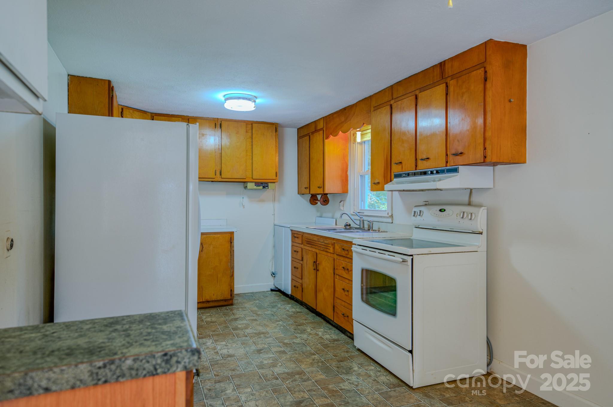 531 Bryson Road Candler, NC 28715 - Photo 27 of 45 a kitchen with stainless steel appliances granite countertop a stove a sink and a microwave