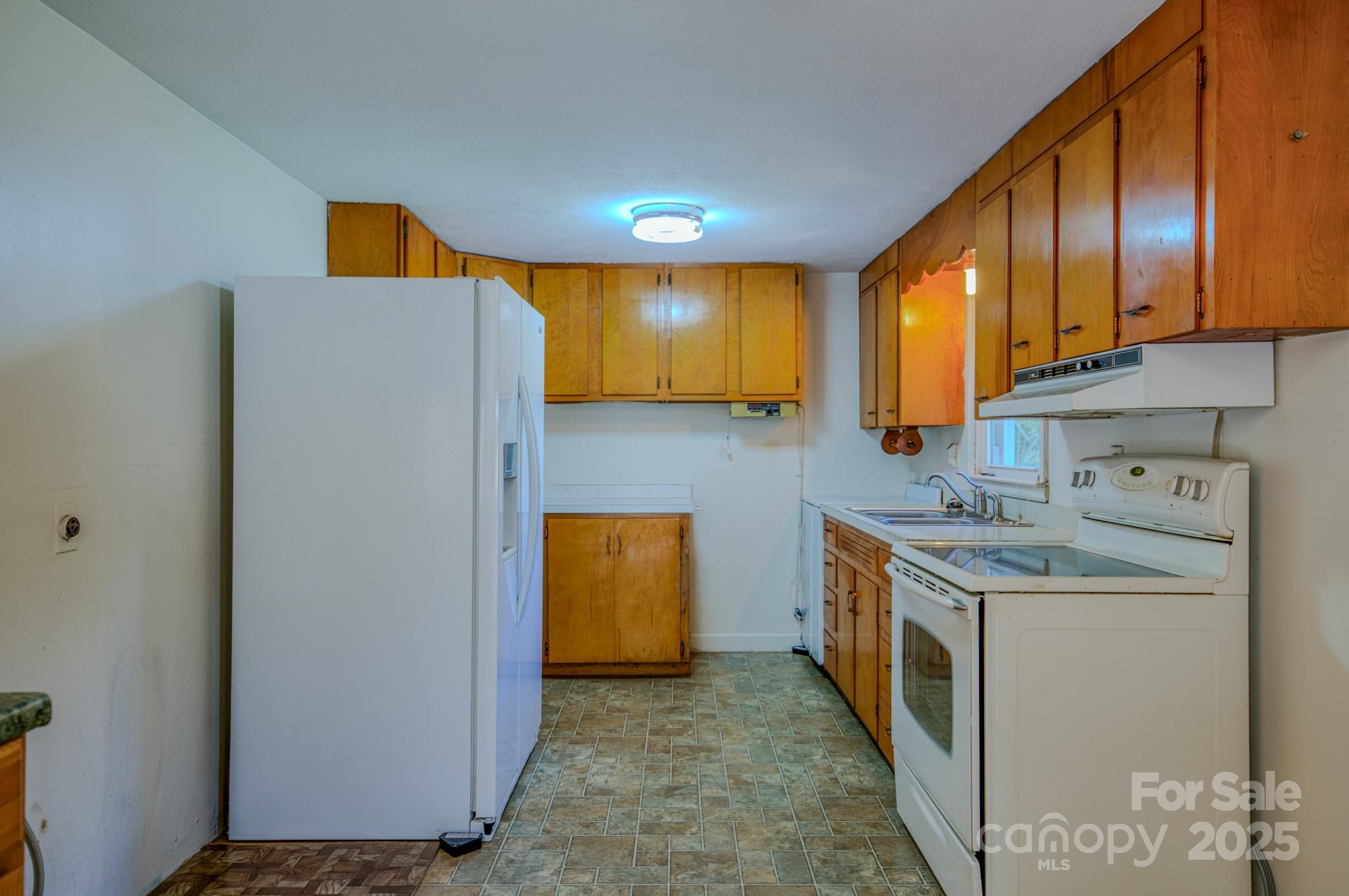 531 Bryson Road Candler, NC 28715 - Photo 28 of 45 a kitchen with a sink a stove and refrigerator