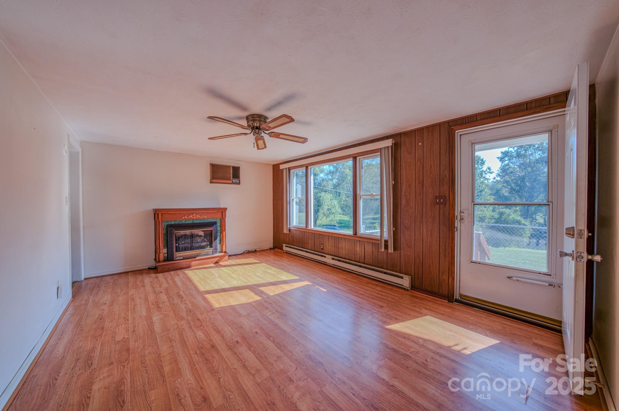 531 Bryson Road Candler, NC 28715 - Photo 9 of 45 a view of an empty room with a window and wooden floor