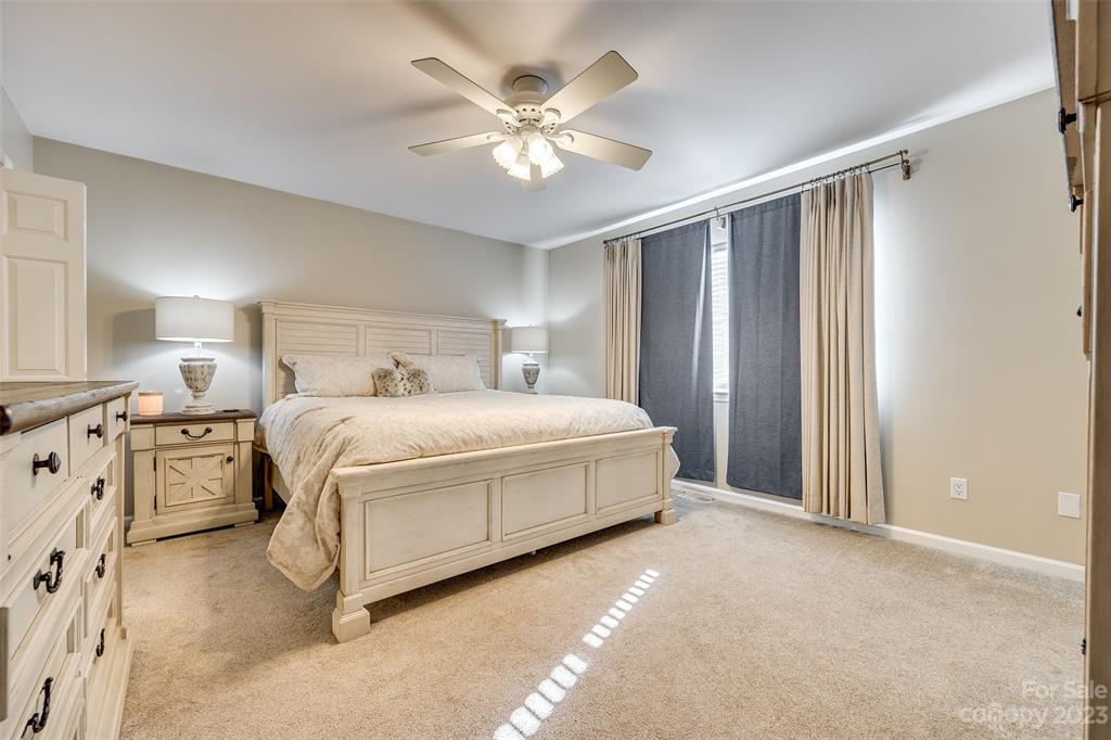 339 Gold Hill Road Fort Mill, SC 29715 - Photo 21 of 48 a spacious bedroom with a bed and a chandelier