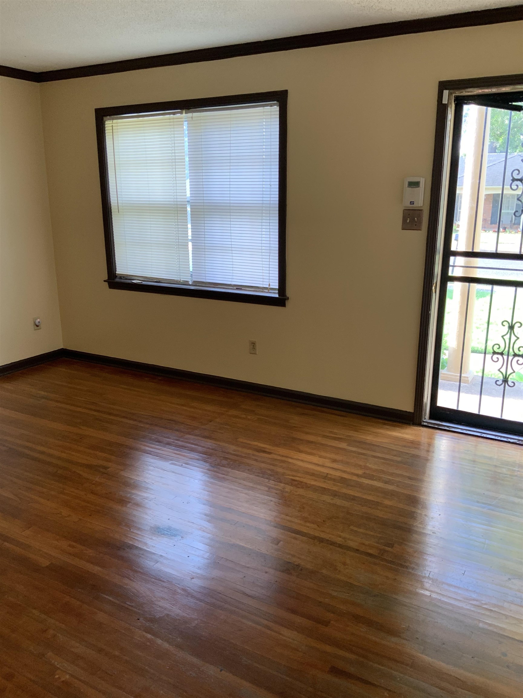 2854 Knightway Road Memphis, TN 38118 - Photo 5 of 16 a view of an empty room with wooden floor and a window