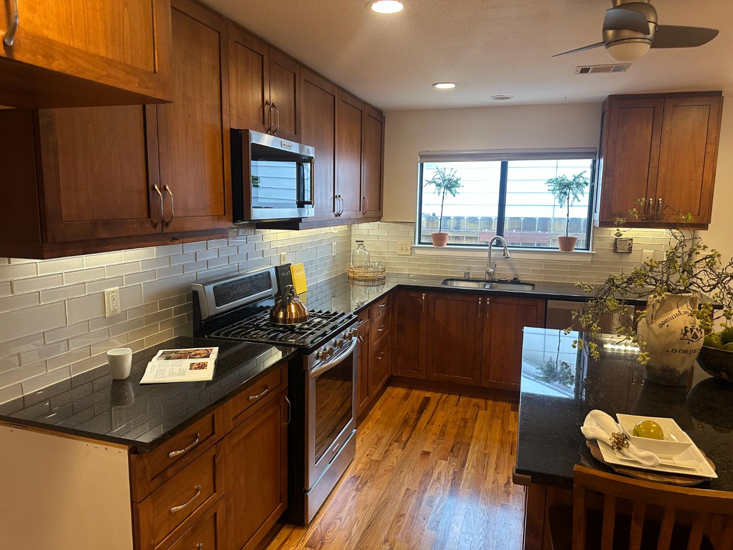 2013 Jerry Lane Lodi, CA 95242 - Photo 13 of 52 a kitchen with granite countertop a stove a sink dishwasher and cabinets with wooden floor