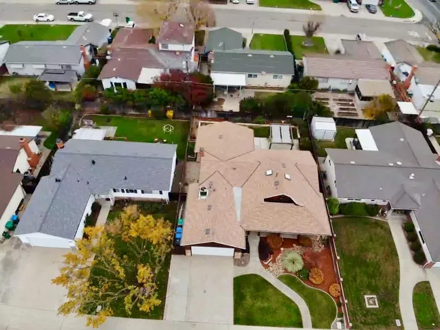 an aerial view of residential houses with outdoor space and parking