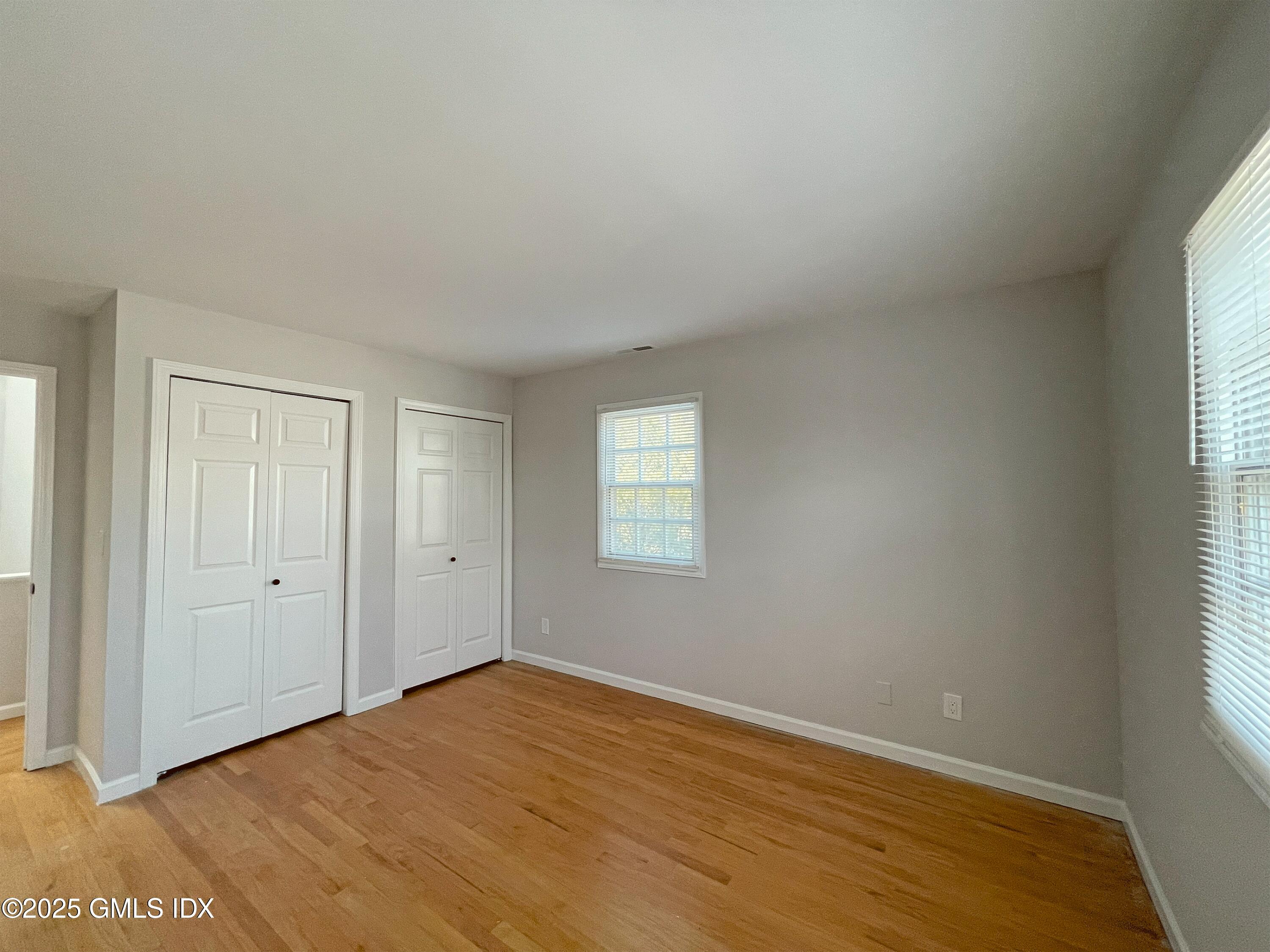 28 Home Place, Unit A2 Greenwich, CT 06830 - Photo 18 of 28 an empty room with wooden floor and windows