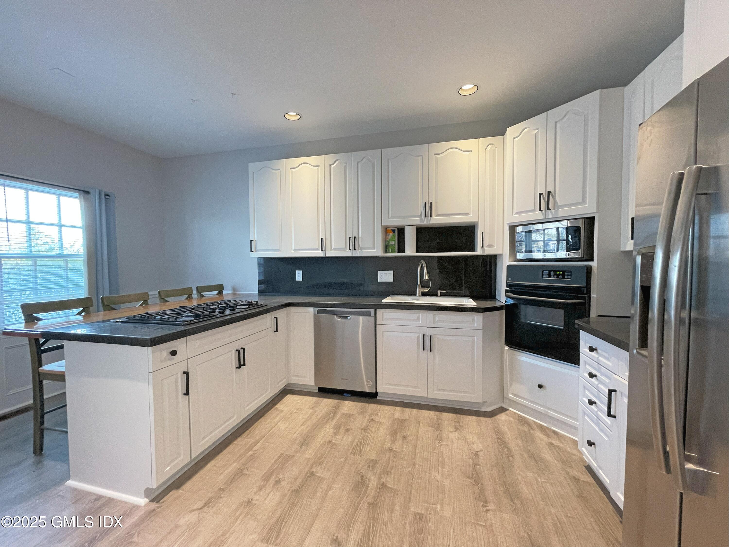 28 Home Place, Unit A2 Greenwich, CT 06830 - Photo 9 of 28 a kitchen with granite countertop a refrigerator and a stove top oven