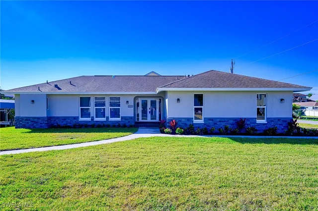 a view of a house with a yard and swimming pool