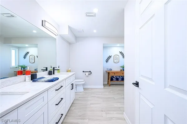 a bathroom with a double vanity sink mirror and toilet
