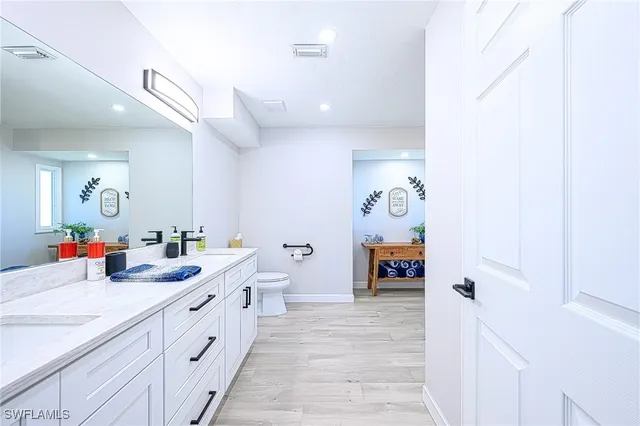 a bathroom with a double vanity sink mirror and toilet