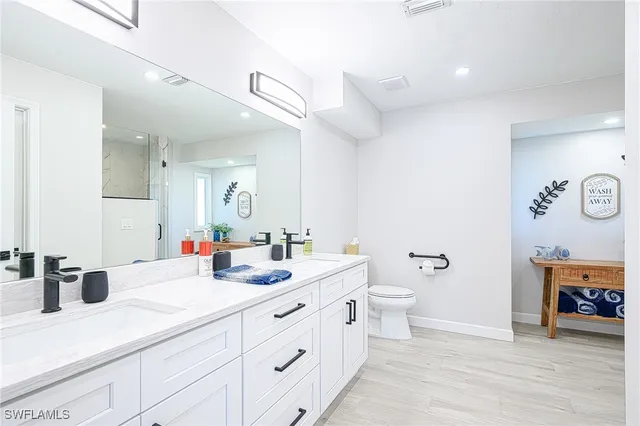 a bathroom with a granite countertop sink a mirror and a shower